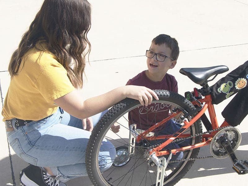 Ford Hall speaks with Adrianna Gutierrez as he inspects his new bike.