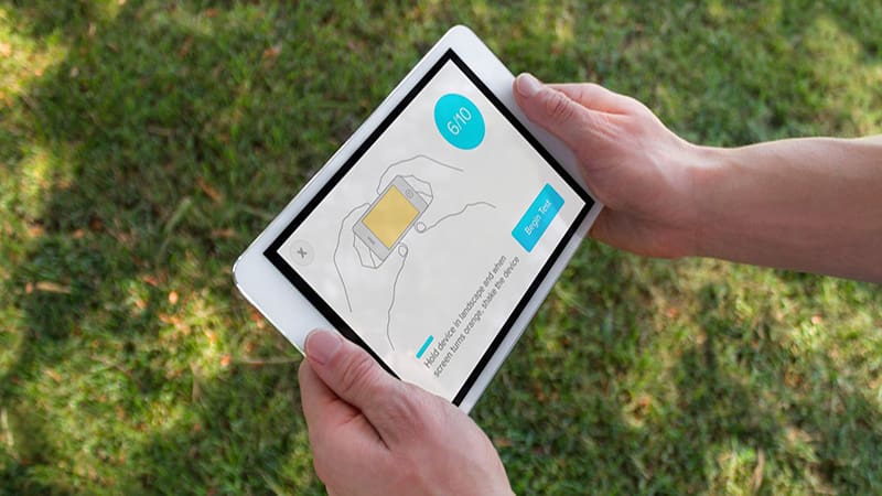 Two hands holding an iPad with the SWAY assessment application instructions displayed on the screen.