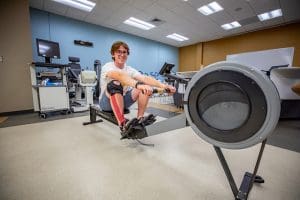 Gianluca Gabriele operating and posing on a rowing machine.