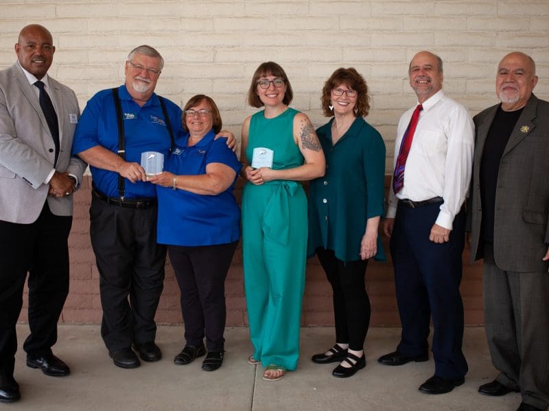Award winners holding their awards and posing with community leaders. Pictured (left to right): Wayne Bell, District Director of Wichita Office of the U.S. Small Business Administration; Mark Buckley, Owner of Toy Depot, Inc.; Geneva Nisly, Owner of Toy Depot, Inc.; Sarah Leslie, Owner of Leslie Coffee Co.; Mary Ware, Kansas State Senator; Tom Sawyer, Kansas State Representative; Frank Choriego, Associate Director of Kansas SBDC at Wichita State University.