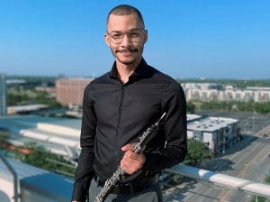 Aaron Robinson, Adjunct Instructor of Oboe, poses with his instrument.