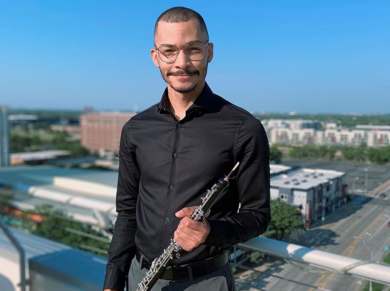 Aaron Robinson, Adjunct Instructor of Oboe, poses with his instrument.