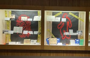 The images showes the exhibit "Crime Scene ICT" It is three different display cases with 2 glass shelves in each case with documents and photographs about the history of Forensic Science in Wichita. The backgound of each case is black with a large red "crime scene" related inmage in each. The first case on the black background is a red fingerprint. In the middle case on the black background is a red outline of a person. On the third case on the black background is a red microscope and vial. Each case has yellow crime scene tape that says "Crime Scene Do Not Cross."