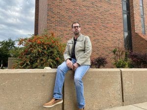 Photo of JW Webster, certified Cherokee language instructor at Wichita State, outside of Lindquist Hall.