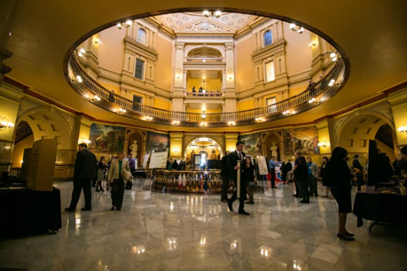 Students presenting research posters in the State Capitol rotunda in Topeka.