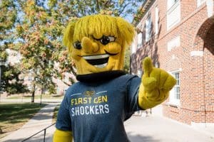 WU supporting First-Gen Shockers. WU wearing a first-gen Shockers t-shirt.