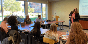 Abigail Devereaux presents a paper to students during an ISEG mentoring group meeting.