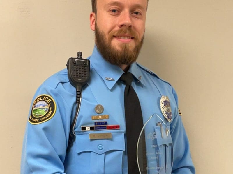 Uniformed Wichita State University Police Officer Dorion holding the Dottie C. Miller Award