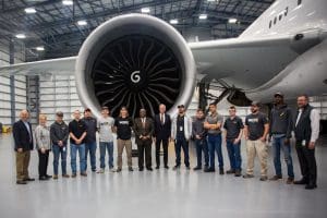 Picture of FAA deputy administrator Bradley Mims and U.S. Senator Jerry Moran with NIAR members in front of jet engine inside NIAR facility.