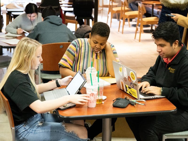 Picture of five students sitting at tables at Fairmont College.