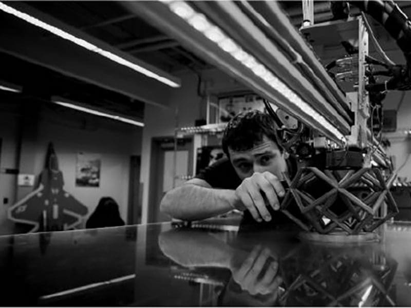 Student using robot to 3D print part.
