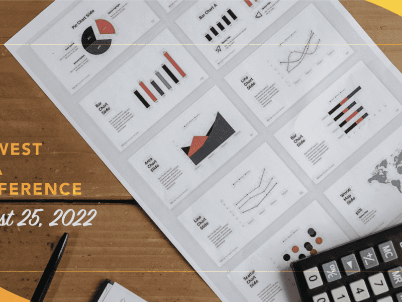 A wood table with a calculator and piece of paper featuring charts and graphics. 2022 Midwest Data Conference on August 25, 2022.
