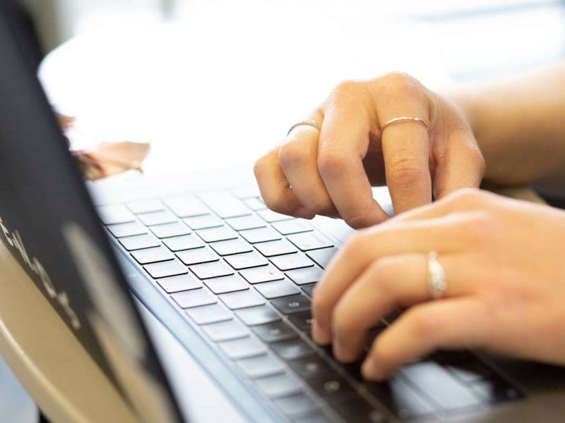 Image of hands typing on laptop.