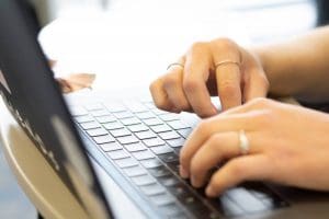 Image of hands typing on laptop.