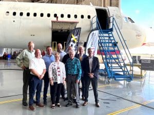 Image of nine member outside aircraft posing for photo at NIAR.