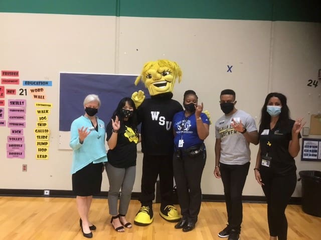 Group picture with Wu in the middle of four Wu Reads volunteers.