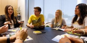 Photo of an office worker assisting students.