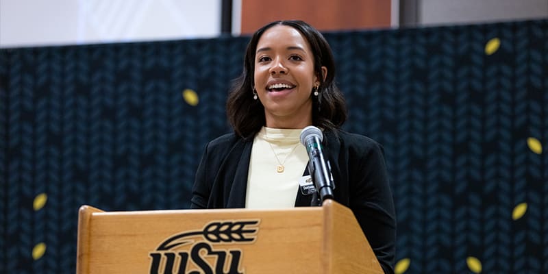 Photo of the student emcee, Destanee Brigman-Reed, speaking at the 2023 scholarship celebration.