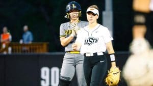Photo of a Shocker softball player behind an OSU player.