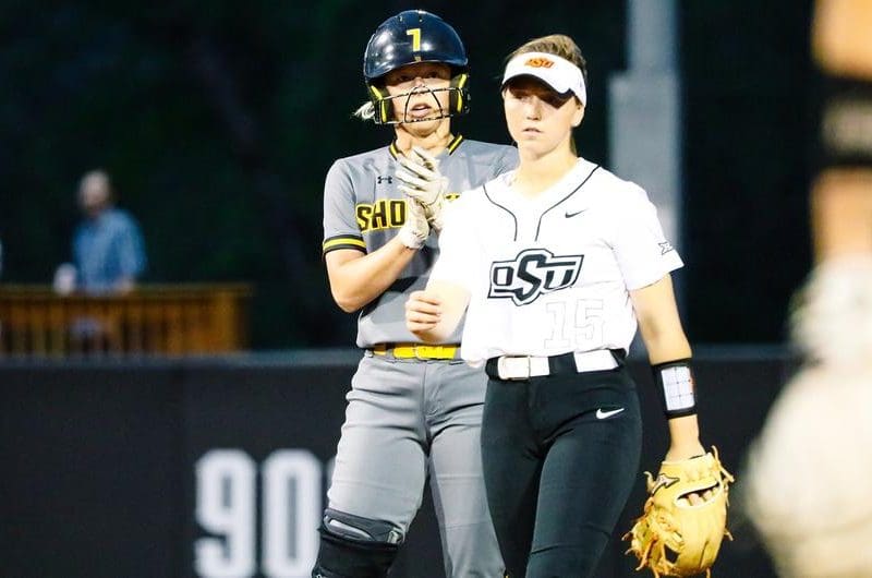 Photo of a Shocker softball player behind an OSU player.