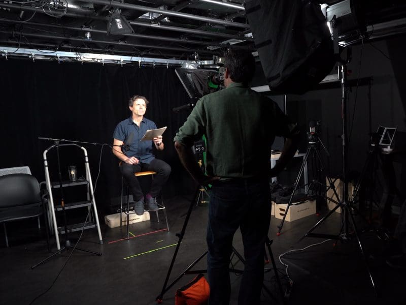 An actor reads a script for a director in a recording studio.