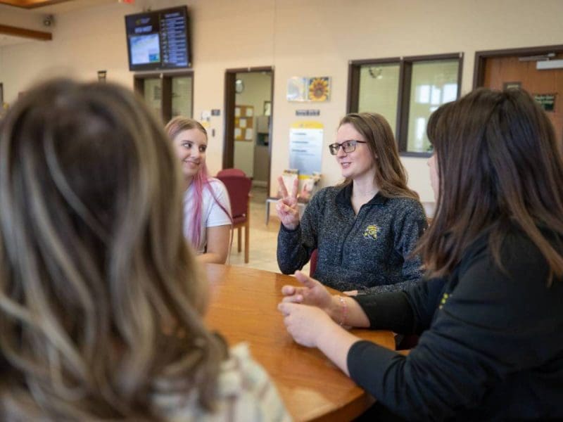 A group of students on the Wichita State campus practicing and signing in ASL.