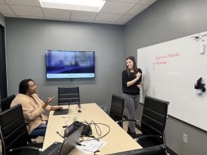 Photo of two students in the Office of Tech Transfer and Commercialization working through a problem on a whiteboard.