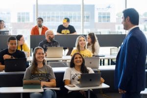 Photo of students in a class engaged in a lecture with a faculty member.