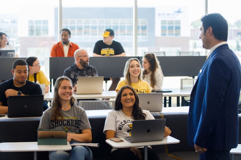 Photo of students in a class engaged in a lecture with a faculty member.