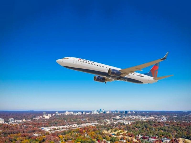 A Delta Airlines plane flying over a city.