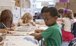 Six children work on their studies in a classroom.