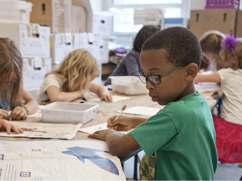 Six children work on their studies in a classroom.