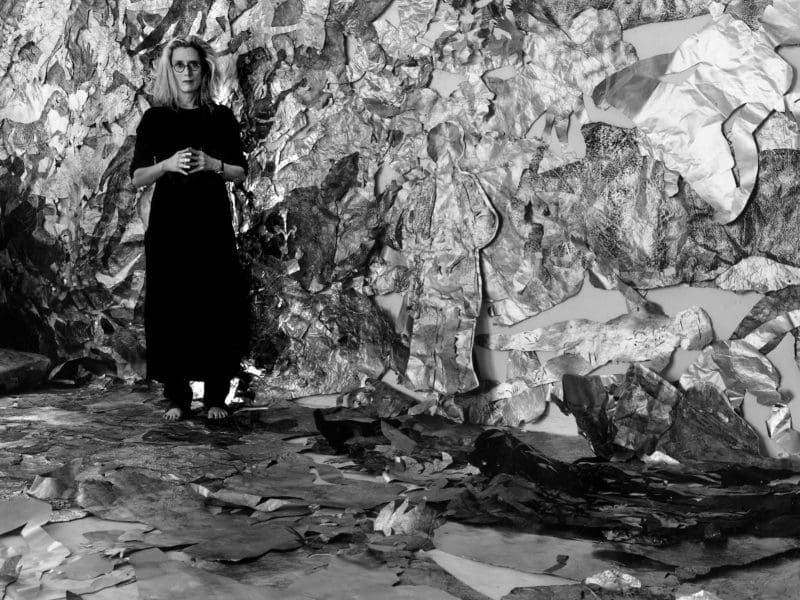 Artist Lesley Dill stands in front of a metallic background in this photo by George Woodman.