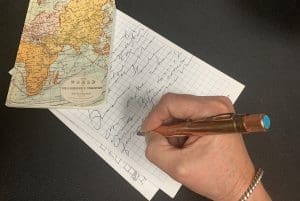 A hand is writing on a note pad.