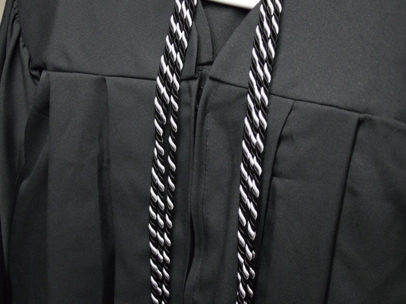 Black and White colored adult learning graduation cord with black graduation robe
