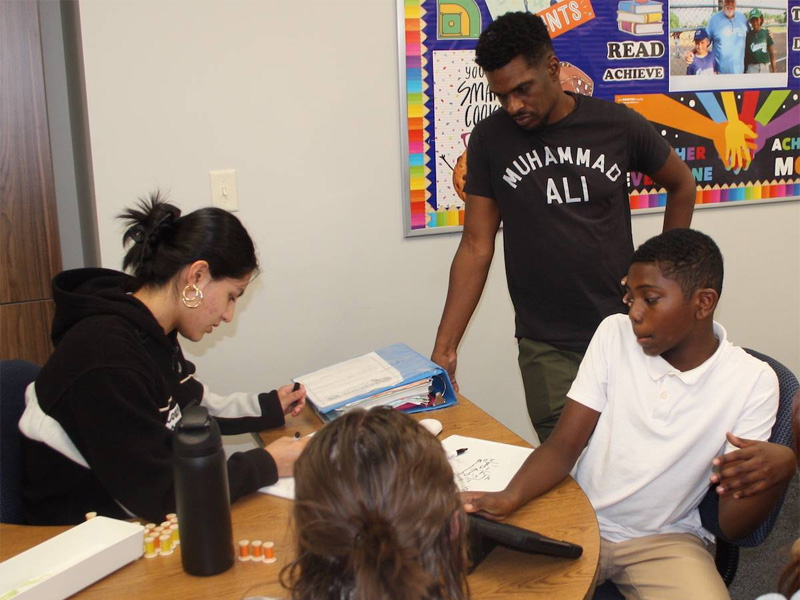 Rudd Scholar Alejandra Facio helps a student with a math assignment at the Leslie Rudd Learning Center