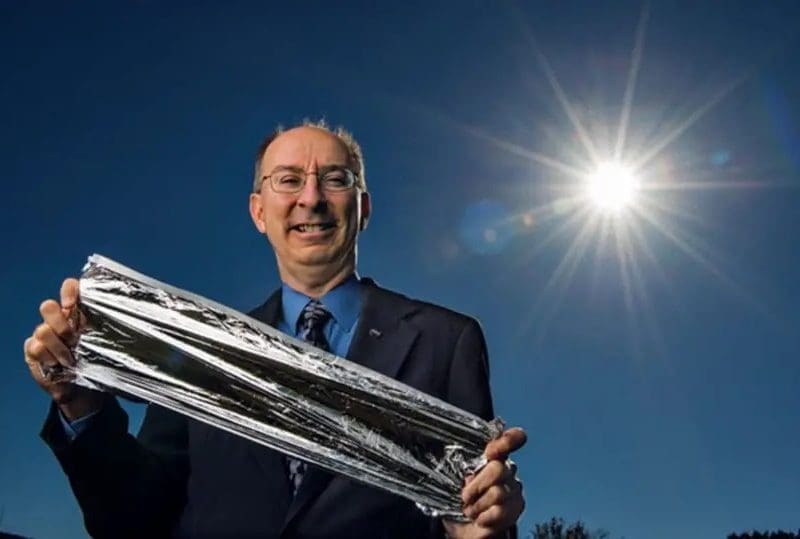 Les Johnson holding a piece of solar sail