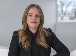 Scholar Marin R. Sullivan, a white, feminine presenting person, looks at the camera.