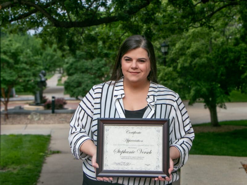 Portrait of Stephanie holding her award