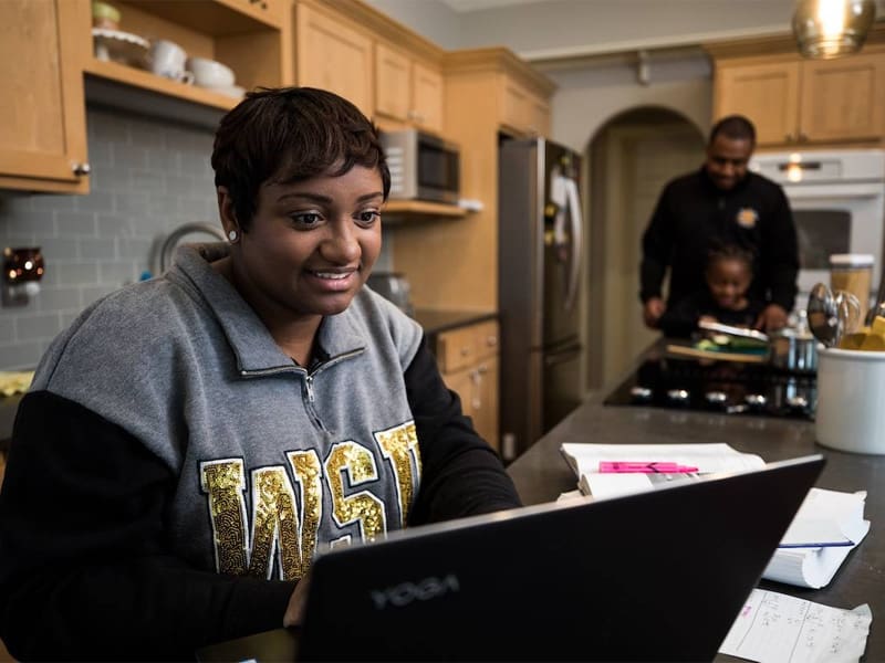 An adult learner works on assignments while at home.