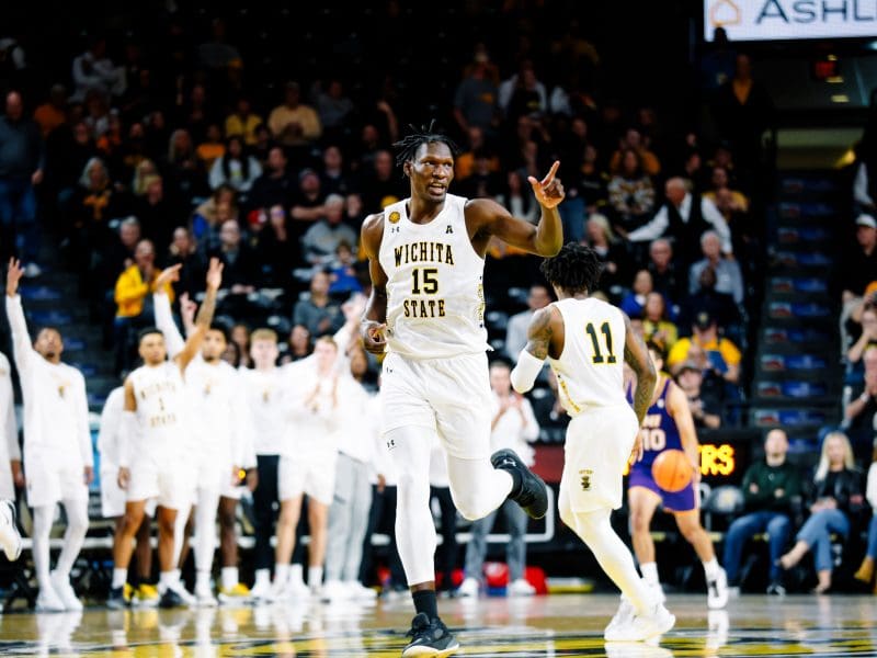 Quincy Ballard points at a teammate while running up the basketball court