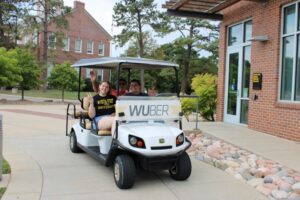 People looking happy in a golf cart.