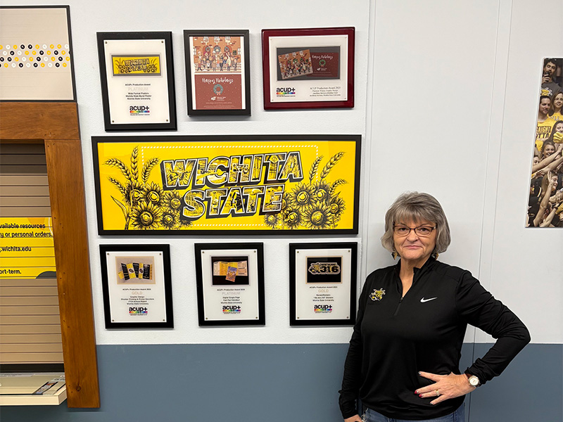Ellen Abbey standing outside of Shocker Printing with awards.