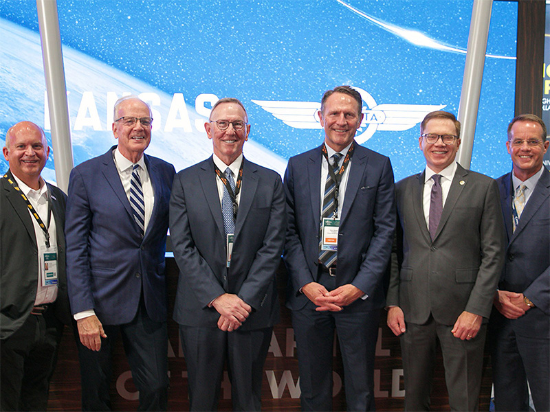 Representatives from Wichita State, Kansas and Orizon pose in front of a digital screen