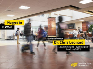 Students walk through a busy indoor campus commons area at Wichita State University. Several people are shown moving across the foreground with motion blur, while others sit and study at tables in the background. Overlay text reads "Plugged In @ WSU" and "A Conversation with Dr. Chris Leonard, Counseling and Psychological Services." The Wichita State University logo appears in the lower-right corner. The image promotes a podcast episode featuring WSU Success Coaches and highlights student activity and engagement on campus.