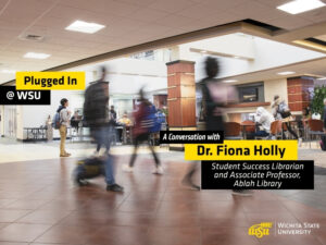 Students walk through a busy indoor campus commons area at Wichita State University. Several people are shown moving across the foreground with motion blur, while others sit and study at tables in the background. Overlay text reads "Plugged In @ WSU" and "A Conversation with Dr. Fiona Holly, Student Success Librarian and Assistant Professor, Ablah Library." The Wichita State University logo appears in the lower-right corner. The image promotes a podcast episode featuring WSU Success Coaches and highlights student activity and engagement on campus.