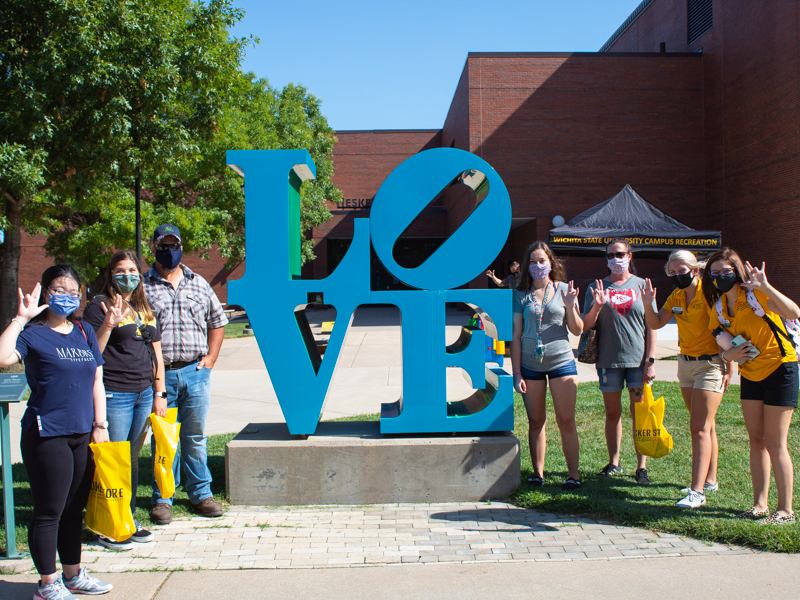 Students posing by statue